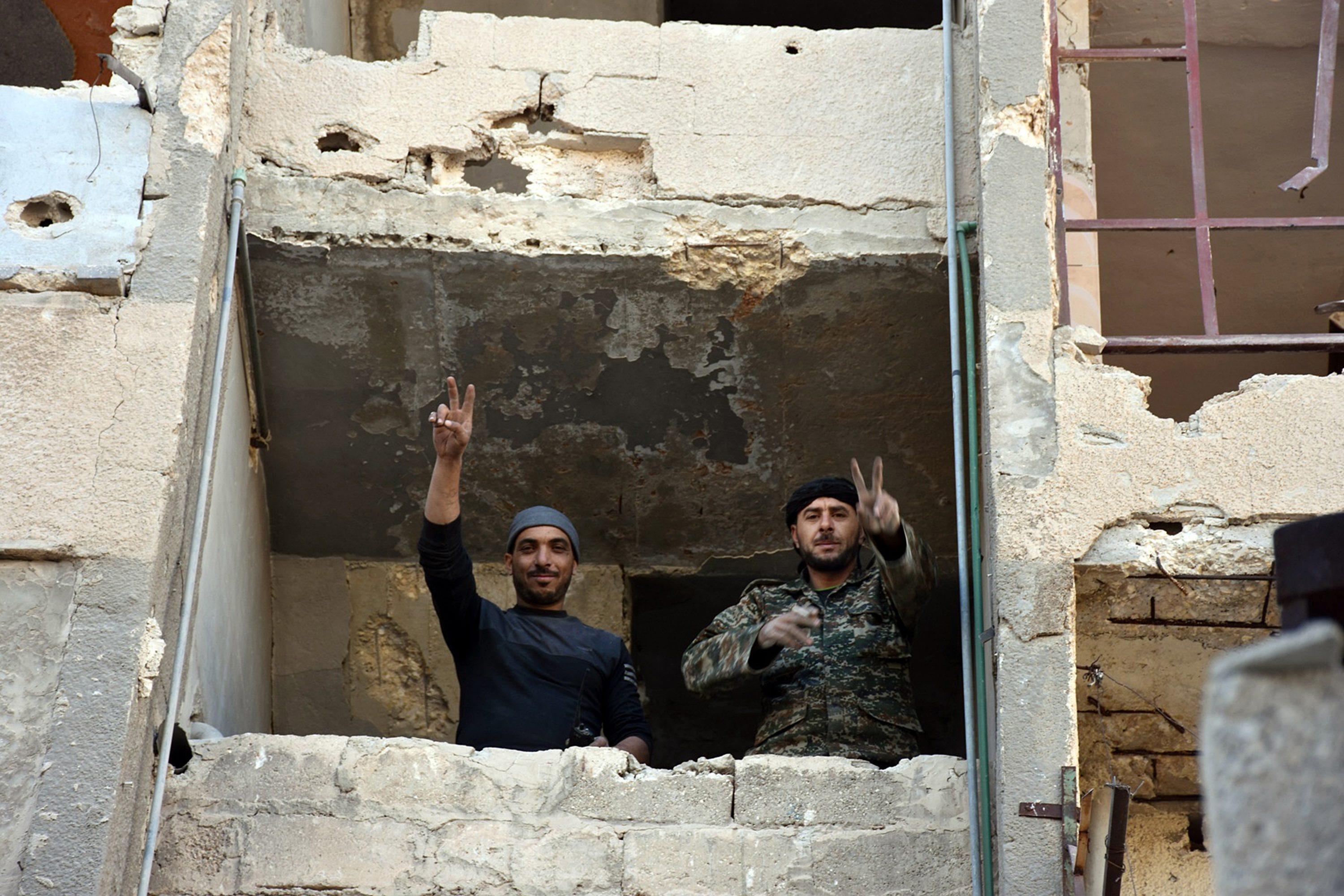 epa05650141 A handout picture made available by the official Syrian Arab News Agency (SANA) shows Syrian soldiers making a V for victory sign from a window of damaged building in Aleppo's eastern Masaken Hanano area in Aleppo province, Syria, 27 November 2016. According to SANA a military source announced on 27 November 2016 that the army units in cooperation with the supporting forces established full control over Jabal Badro neighborhood and Masaken Hanano area in Aleppo . EPA/SANA HANDOUT HANDOUT EDITORIAL USE ONLY/NO SALES