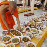 Un monaco buddista prepara i tavoli per il pranzo