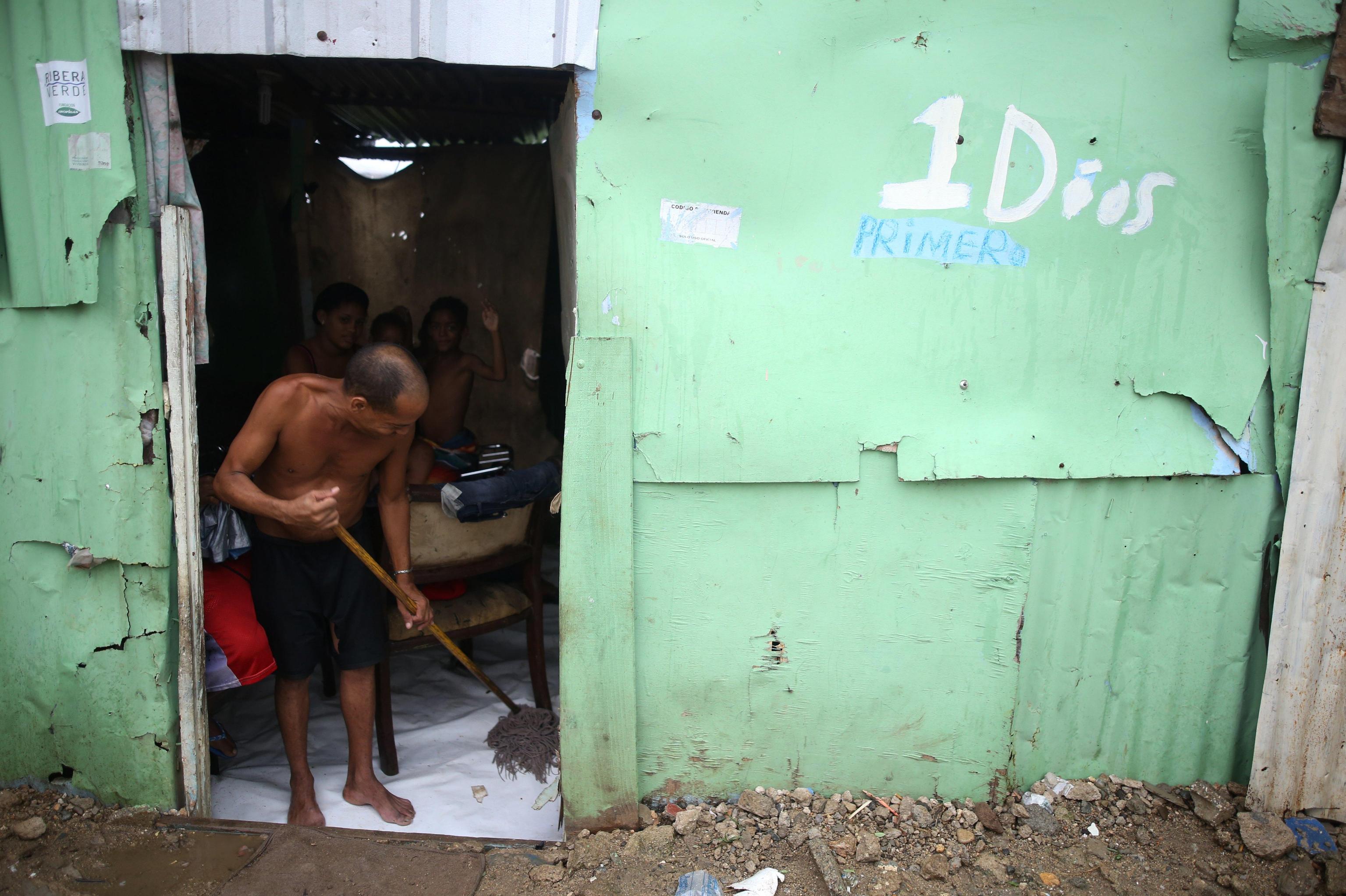 Santo Domingo, Rep. Domenicana. Uomo cerca di ripulire la sua abitazione