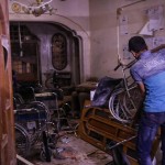 Un uomo solleva una delle sedie a rotelle che si trova all'interno del centro colpito dalla bomba Un uomo solleva una delle sedie a rotelle che si trova all'interno del centro colpito dalla bomba