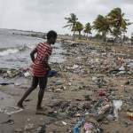 Cap Haitian, Haiti. Ragazzo su una spiaggia ricoperta da detriti Cap Haitian, Haiti. Ragazzo su una spiaggia ricoperta da detriti