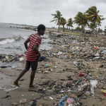 Cap Haitian, Haiti. Ragazzo su una spiaggia ricoperta da detriti