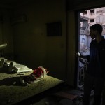 Servendosi della torcia di un cellulare, un ragazzo osserva le macerie Servendosi della torcia di un cellulare, un ragazzo osserva le macerie