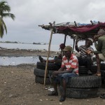 Cap Haitian, Haiti. Un gruppo di uomini dinnanzi all'inondazione Cap Haitian, Haiti. Un gruppo di uomini dinnanzi all'inondazione