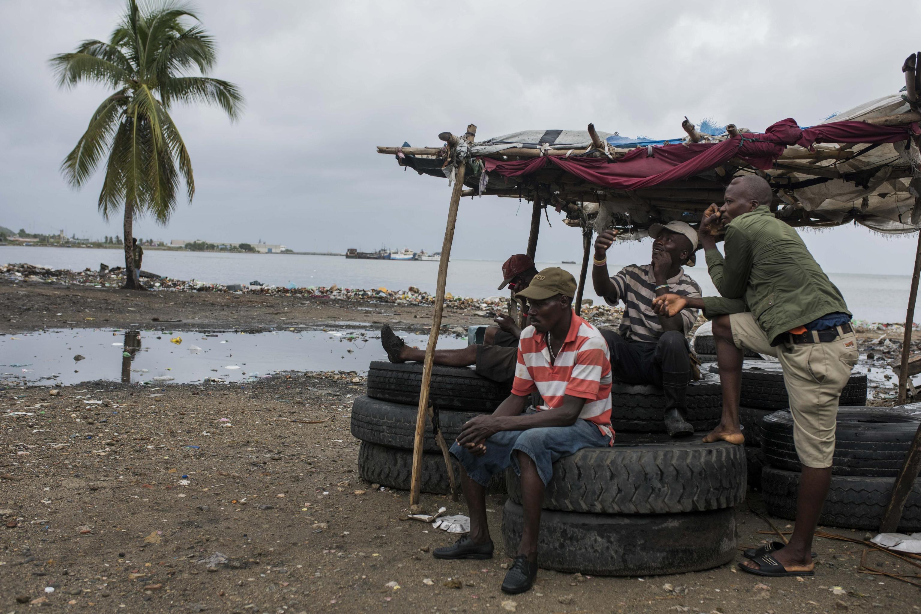 Cap Haitian, Haiti. Un gruppo di uomini dinnanzi all'inondazione Cap Haitian, Haiti. Un gruppo di uomini dinnanzi all'inondazione