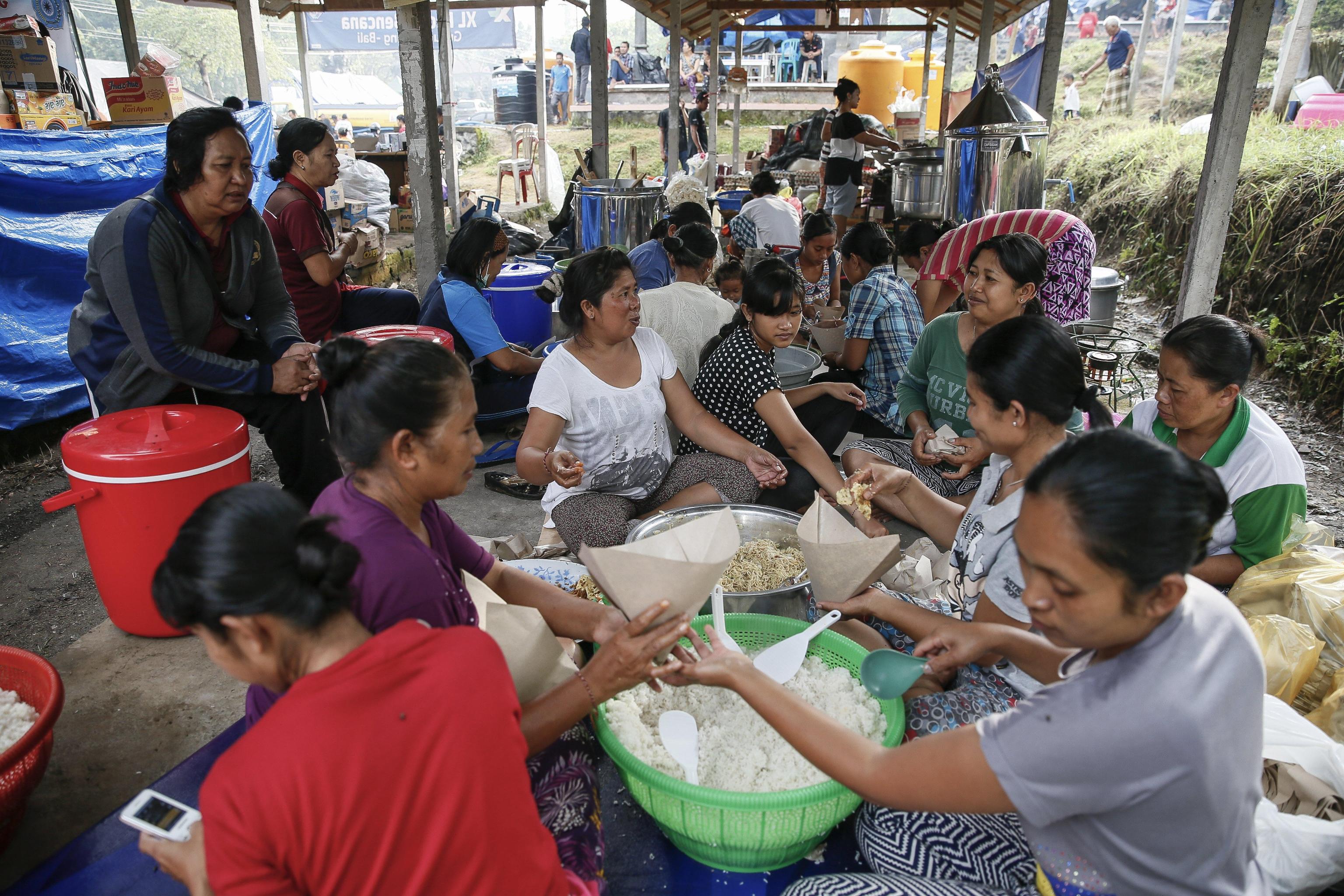Gli sfollati preparano da mangiare nel rifugio situato nella regione del Karangasem Gli sfollati preparano da mangiare nel rifugio situato nella regione del Karangasem