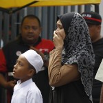 Una donna si dispera alla vista della scuola incediata