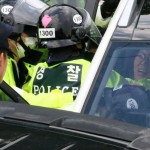 Poliziotto afferra una manifestante durante la protesta