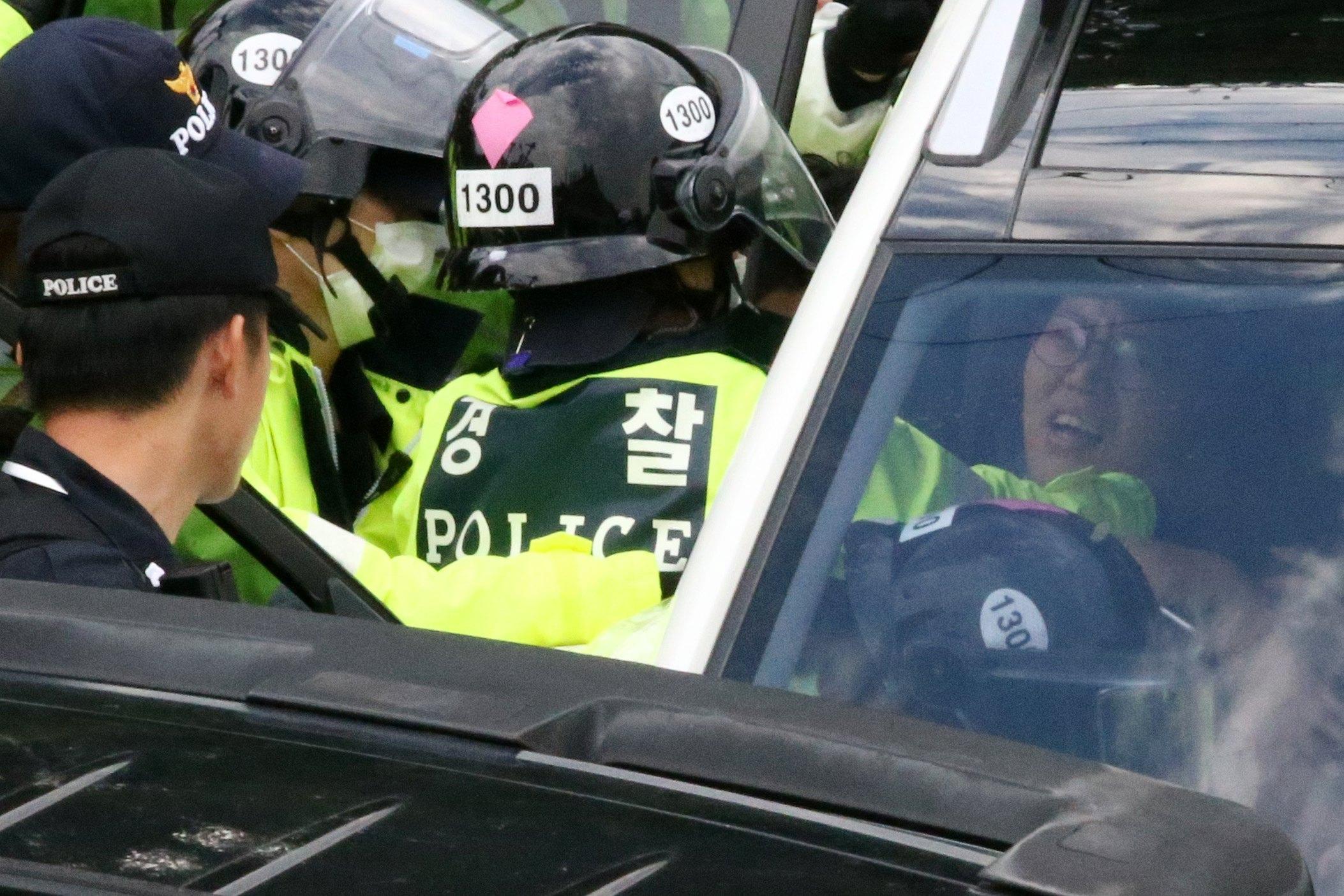 Poliziotto afferra una manifestante durante la protesta