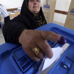 Una donna curdo irachena getta la scheda nell'urna