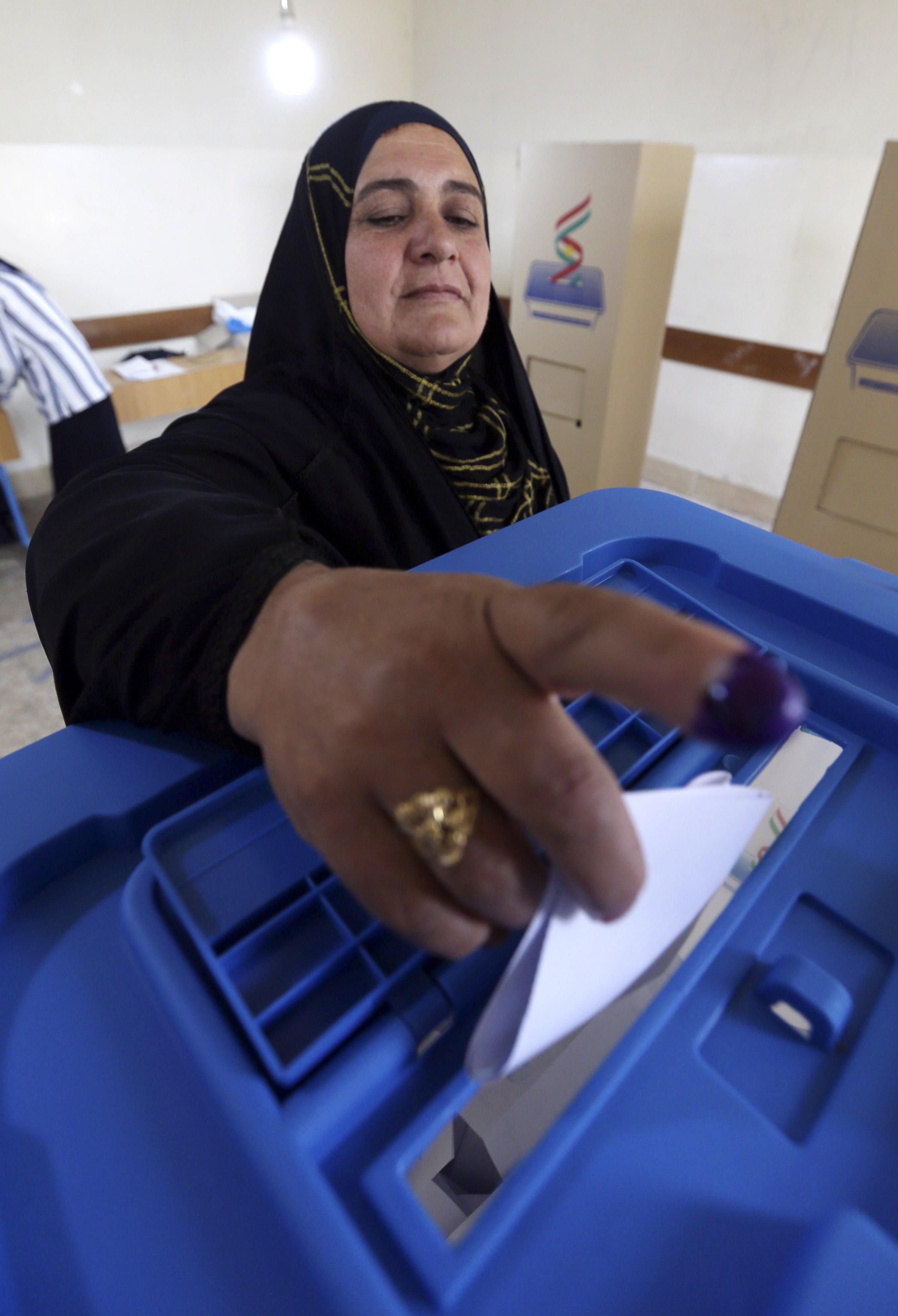 Una donna curdo irachena getta la scheda nell'urna