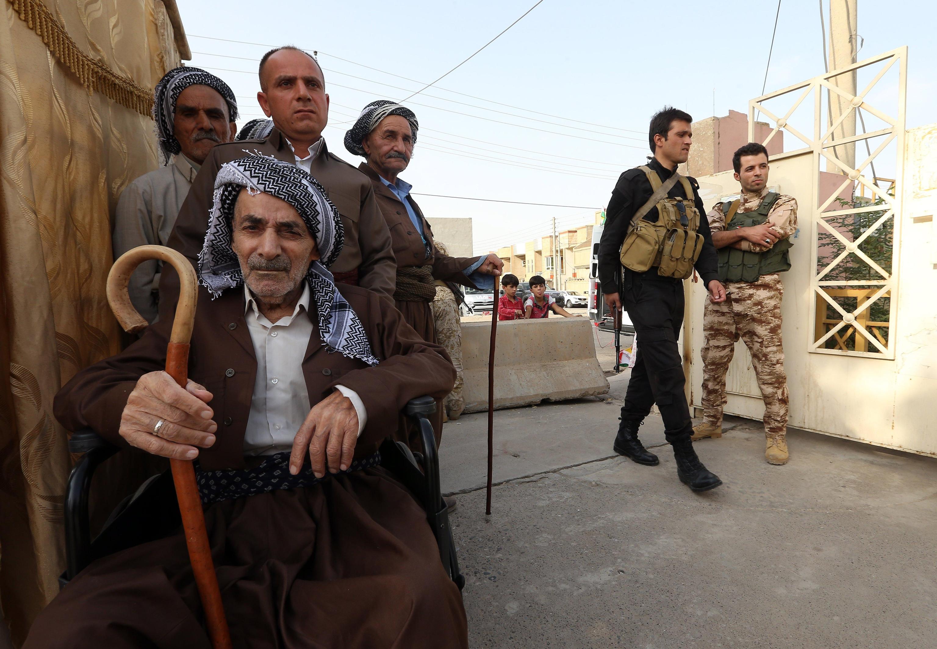 Un gruppo di anziani all'entrata di un seggio a Erbil