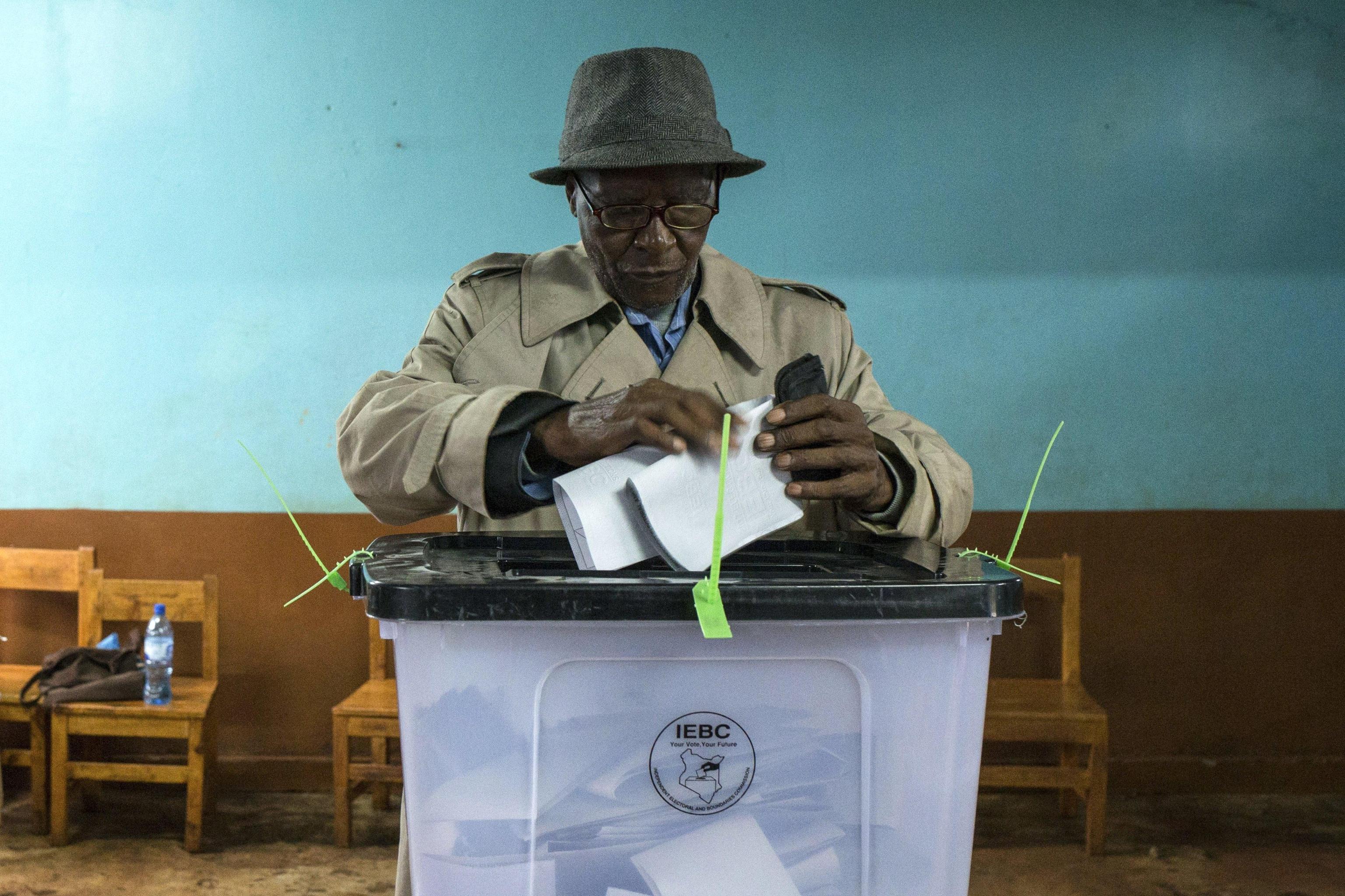 Un cittadino keniota inserisce il suo voto nell'urna al seggio della scuola elementare Mutomo, a Gatundu. I seggi si sono aperti stamattina alle 5.