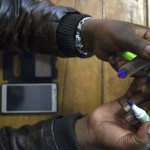 Un funzionario di segnalazione contrassegna il dito di un elettore con un segnalino alla stazione di voto di Mutomo della scuola elementare di Mutomo a Gatundu, Kenya