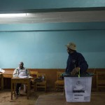 Un votante si volta verso il controllore del seggio nella scuola elementare. Le elezioni si ripetono dopo il recente annullamento dell'8 agosto da parte della Corte Suprema per "irregolarità e illegalità". Un votante si volta verso il controllore del seggio nella scuola elementare. Le elezioni si ripetono dopo il recente annullamento dell'8 agosto da parte della Corte Suprema per "irregolarità e illegalità".