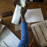 Un cittadino keniota consegna il suo documento al seggio di Gatundu e riceve la scheda elettorale. Il leader dell'opposizione Odinga ha ritirato la sua candidatura, accusando la Commissione elettorale di non produrre elezioni credibili.