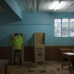 Un cittadino vota sotto il controllo del commissario. Il leader dell'opposizione Odinga ha rinunciato a partecipare alle elezioni dopo aver ottenuto l'annullamento delle precedenti in agosto, accusando la Commissione elettorale di essere dalla parte di Kenyatta