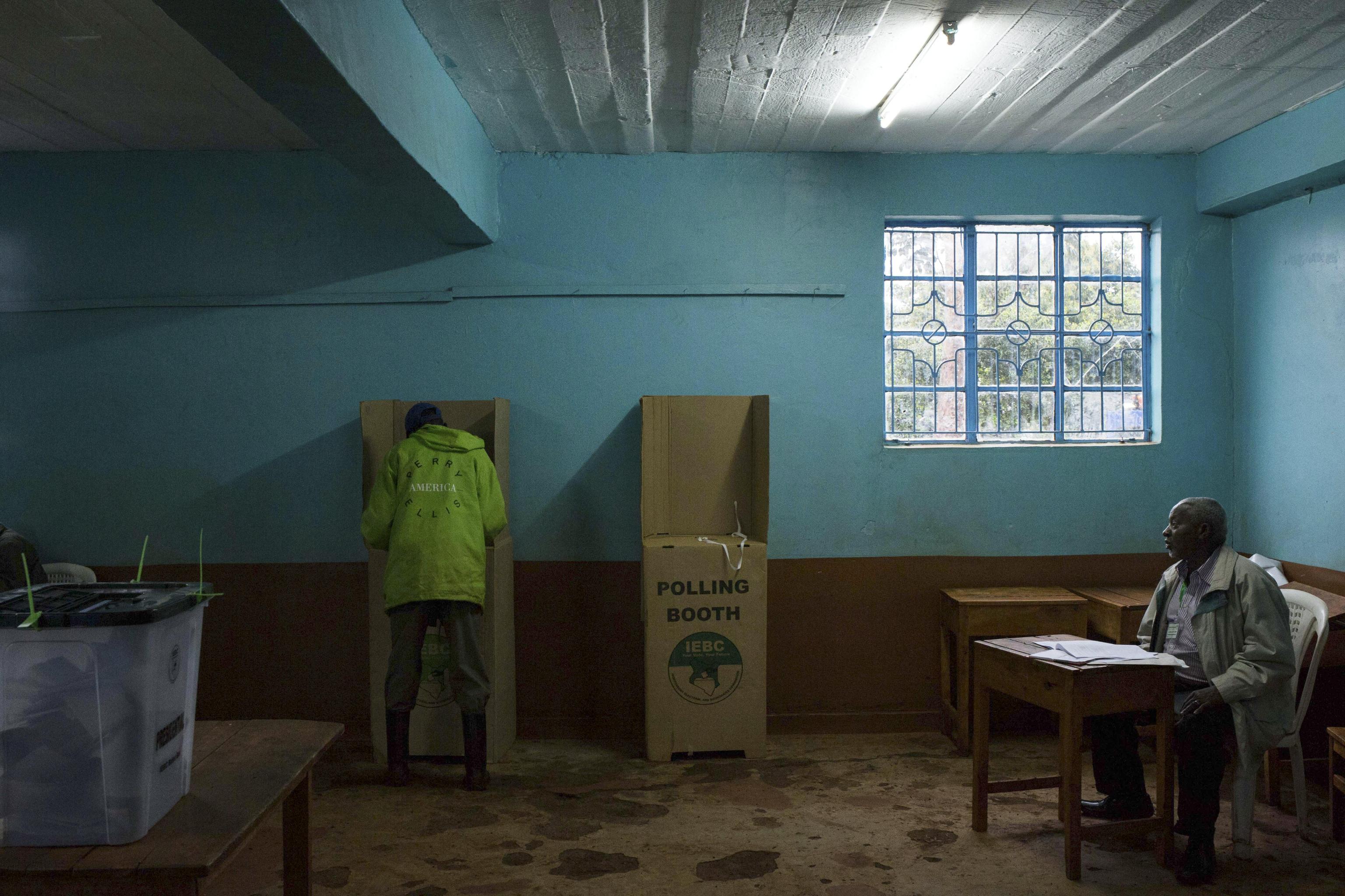 Un cittadino vota sotto il controllo del commissario. Il leader dell'opposizione Odinga ha rinunciato a partecipare alle elezioni dopo aver ottenuto l'annullamento delle precedenti in agosto, accusando la Commissione elettorale di essere dalla parte di Kenyatta