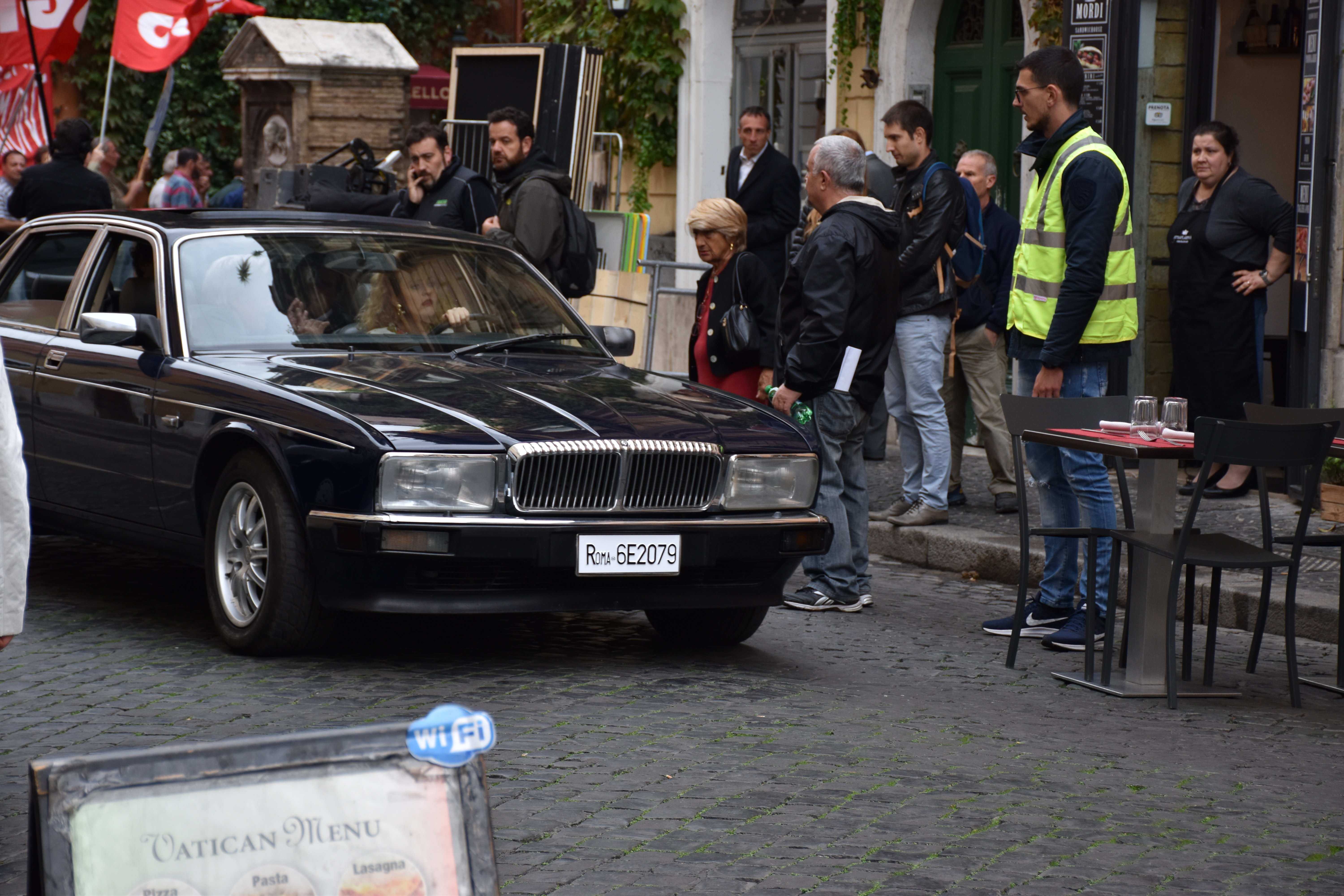 L'attrice Marina Rocco guida l'auto su cui c'è Bettino Craxi che sta lasciando l'Hotel Raphael
