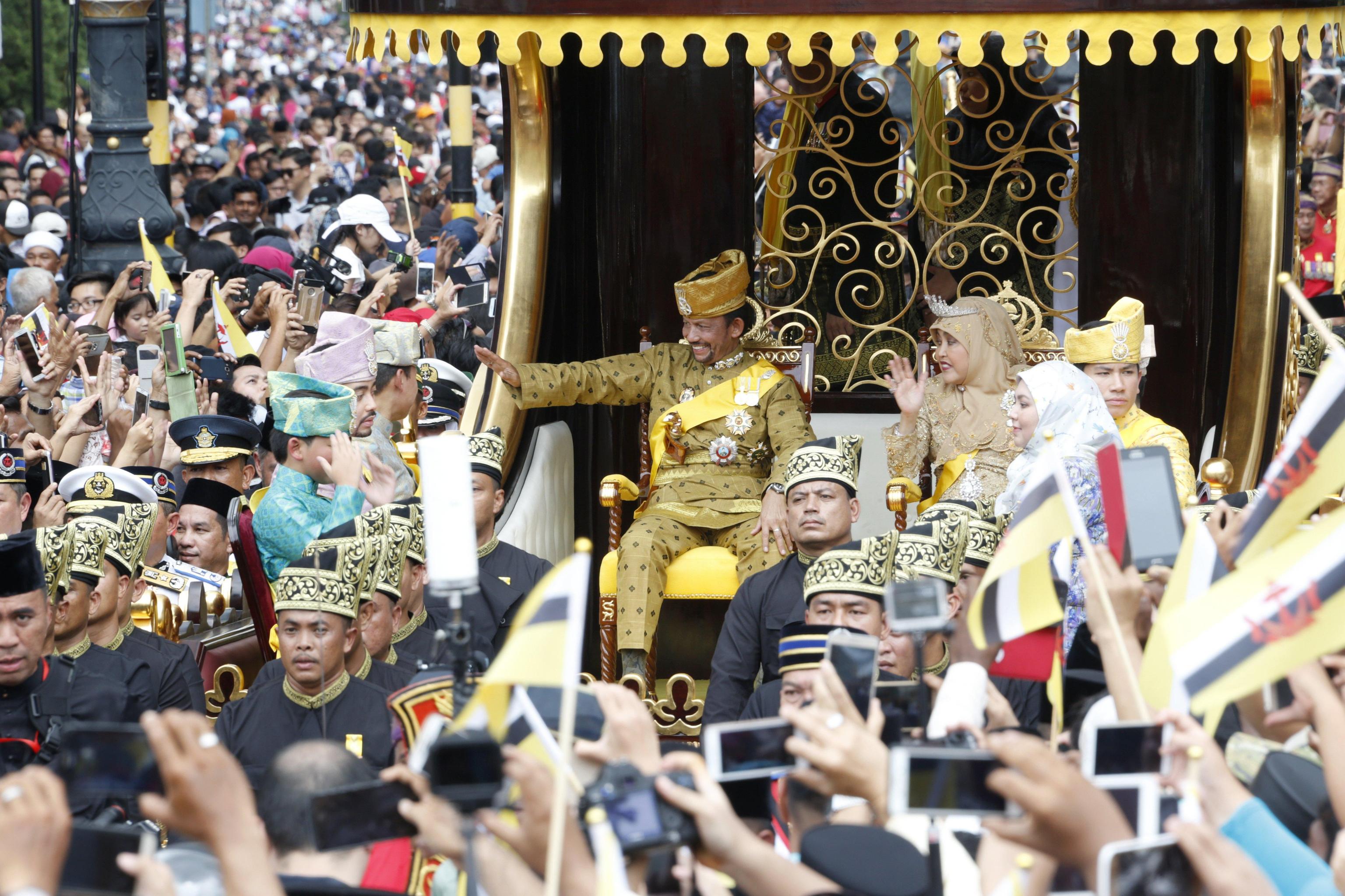 Il Sultano e la regina sfilano sopra un carro d'oro