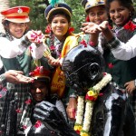 Un gruppo di studentesse depone dei fiori su una statua di Gandhi a Bangalore