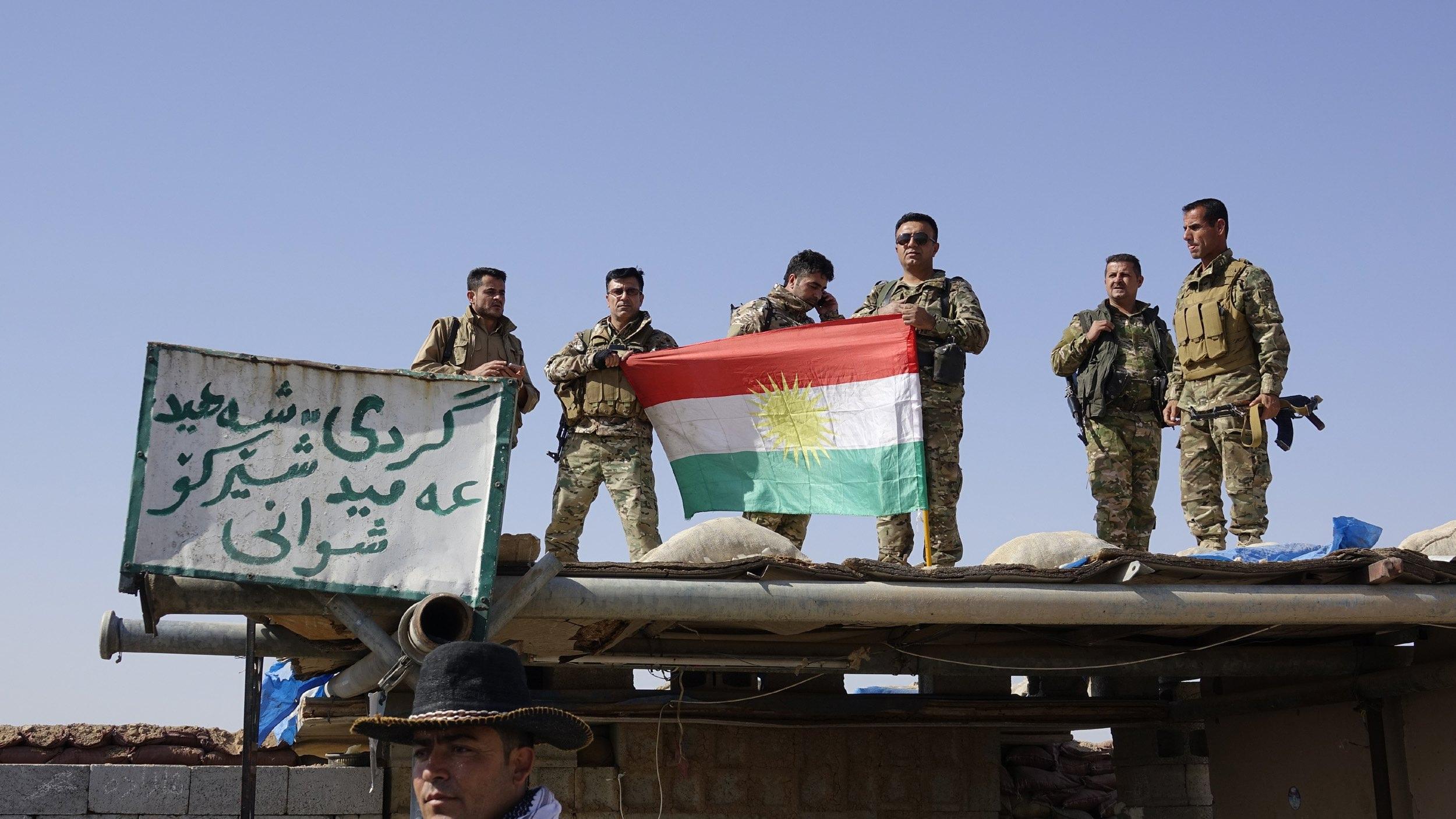Soldati curdi mostrano la bandiera del Kurdistan