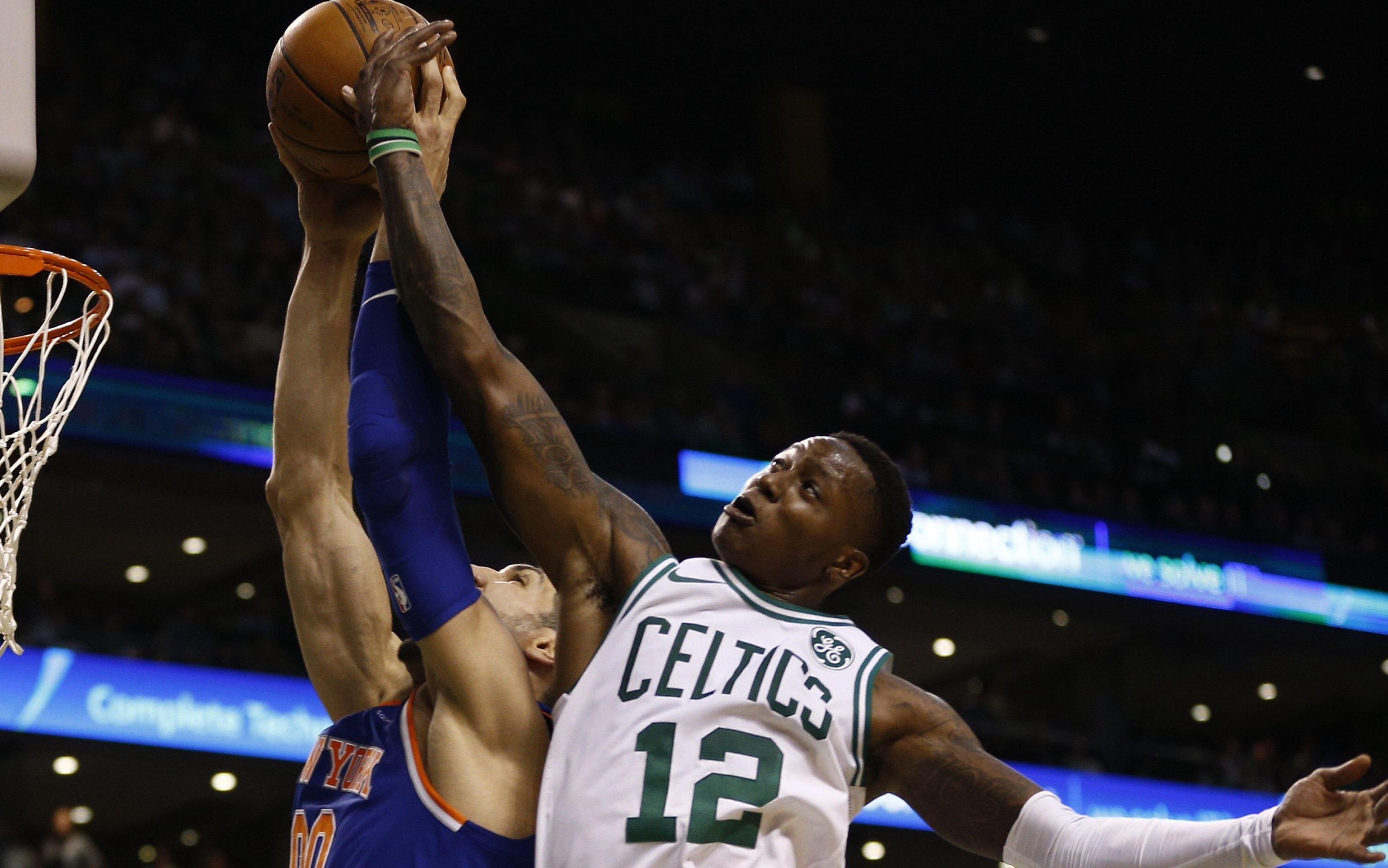 La guardia dei Celtics Terry Rozier cerca di stoppare il tiro del centro Enes Kanter