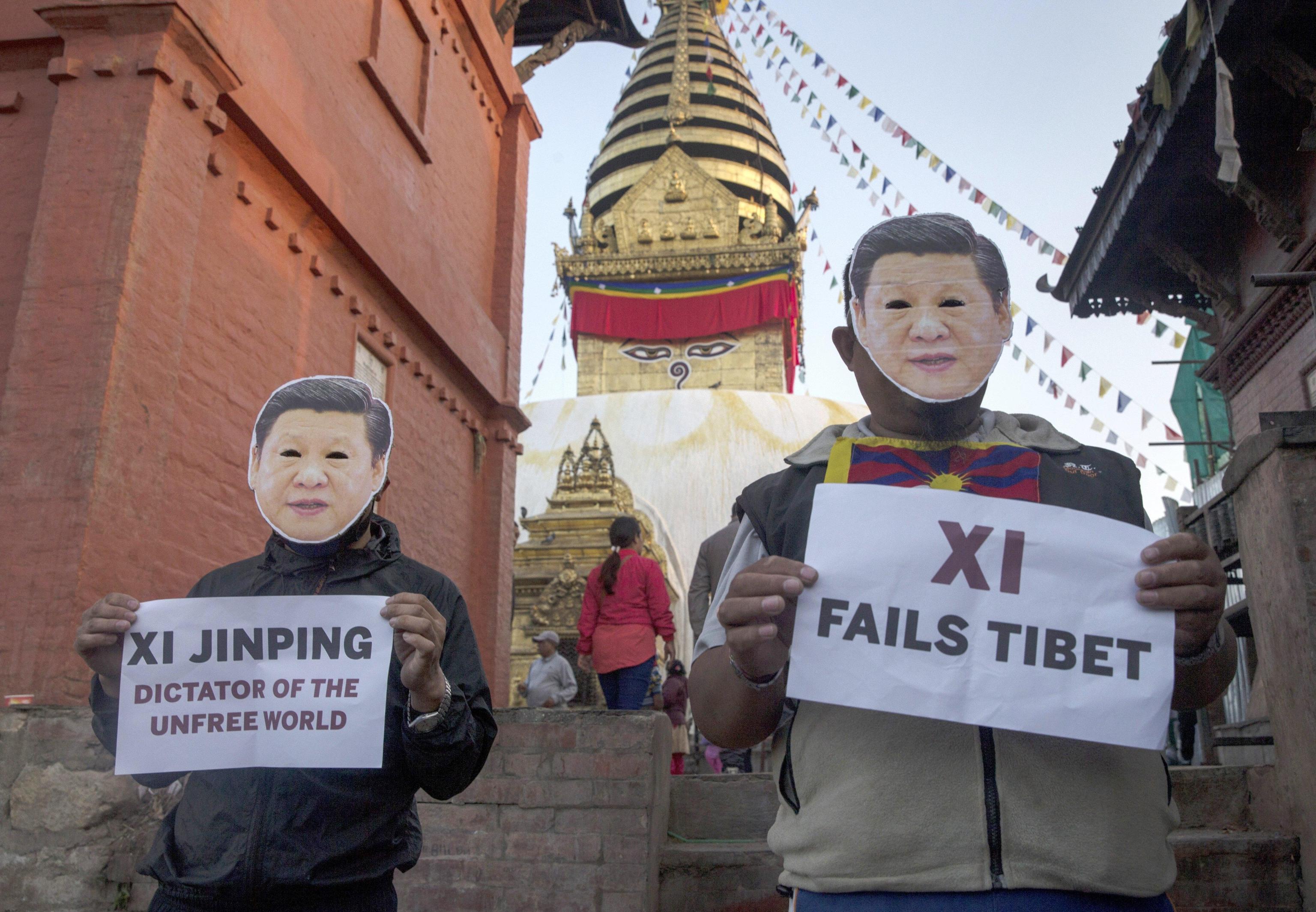 Attivisti tibetani esiliati inscenano una protesta a Kathmandu, in Nepal, vestendo maschere che rappresentano il Presidente cinese Xi Jinping