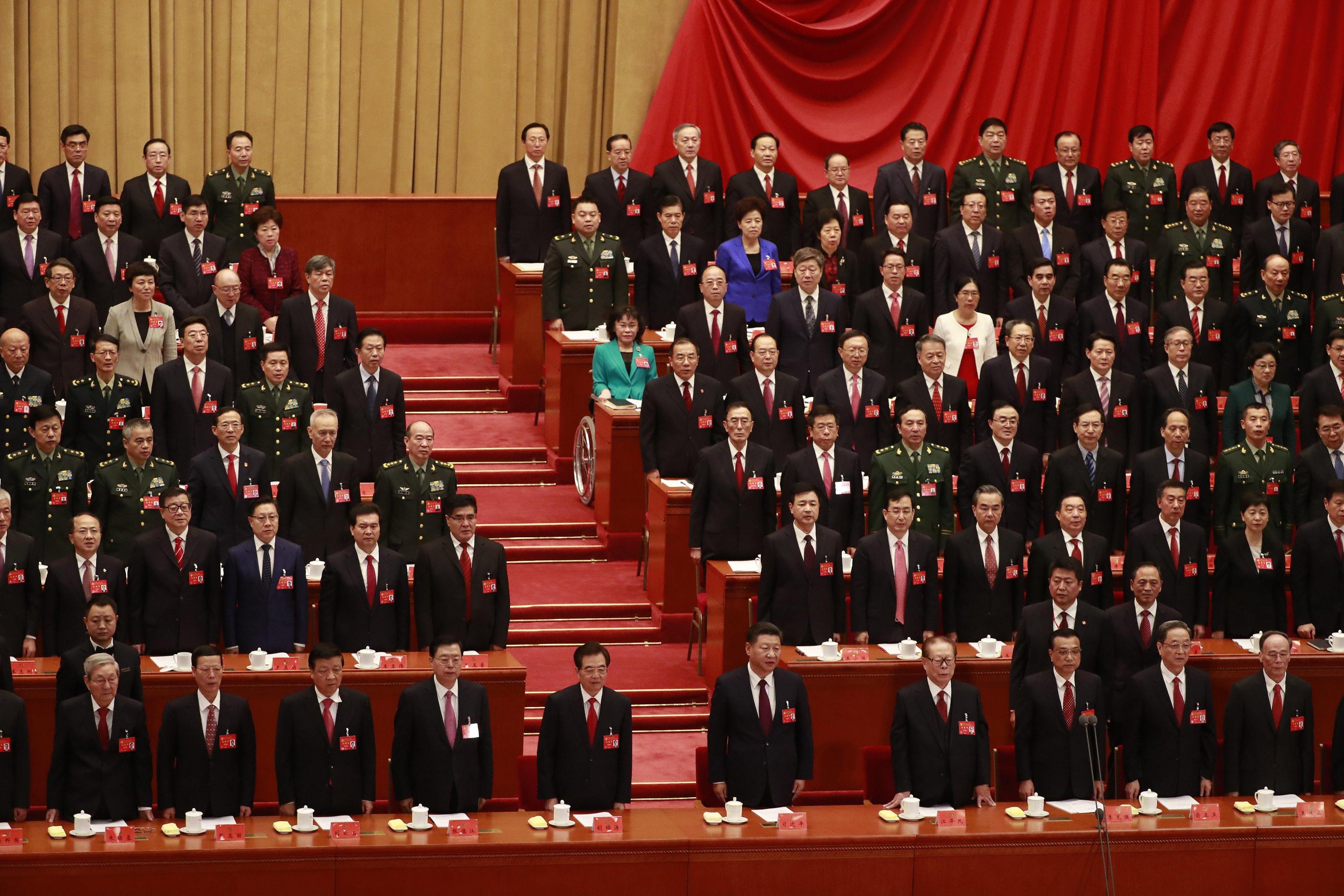 Il Presidente Xi Jinping, il premier Li Keqiang ed alle loro spalle i delegati, in piedi durante la cerimonia di apertura