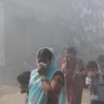 Cittadini a Calcutta camminano tra i fumi della disinfestazione