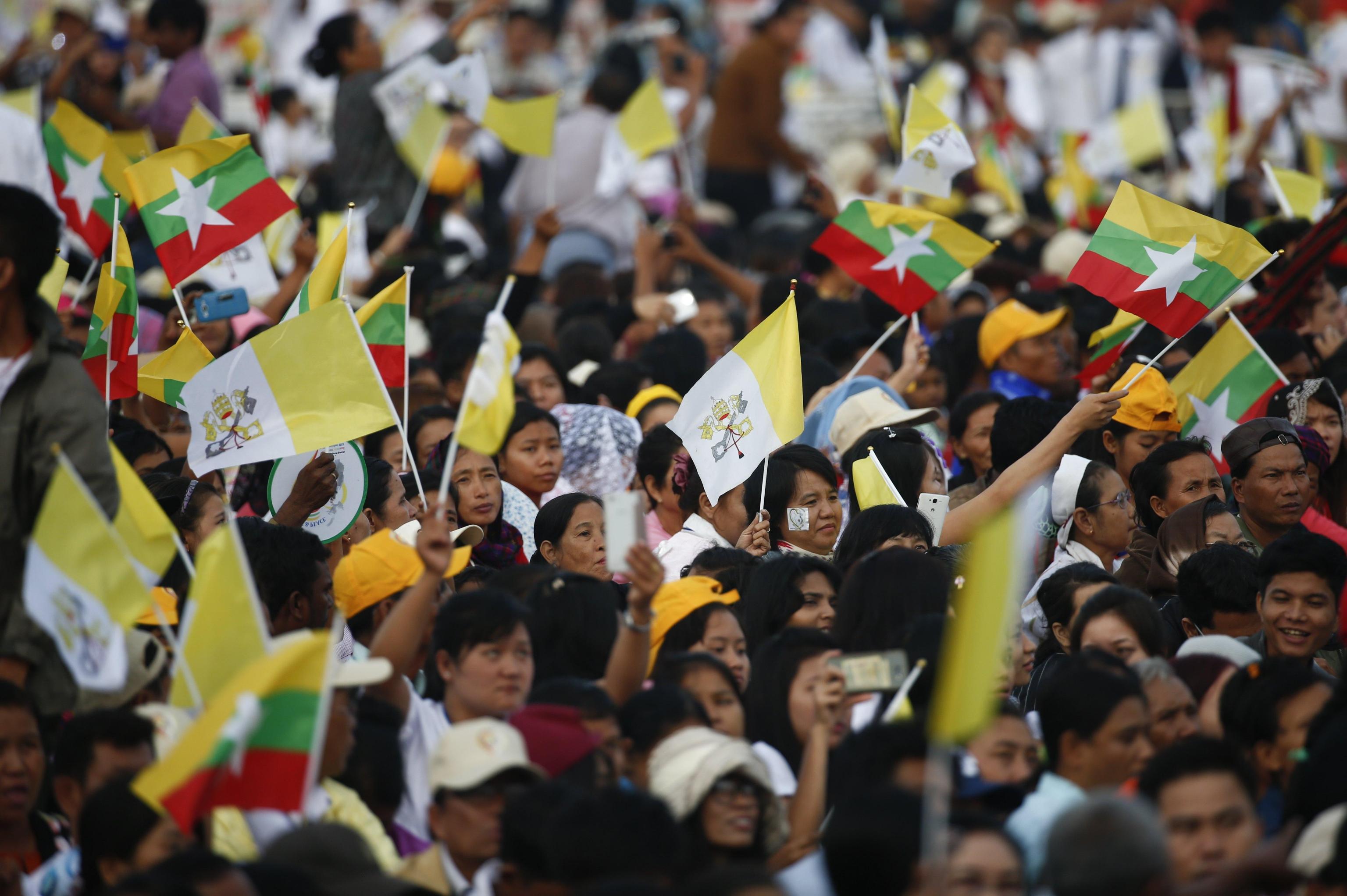 La folla che ha accolto il Pontefice, con bandiere del Myanmar e del Vaticano