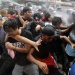 Giovani manifestanti scappano dalla carica della polizia
