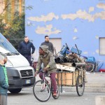 Un giovane di colore con una bicicletta e i suoi bagagli