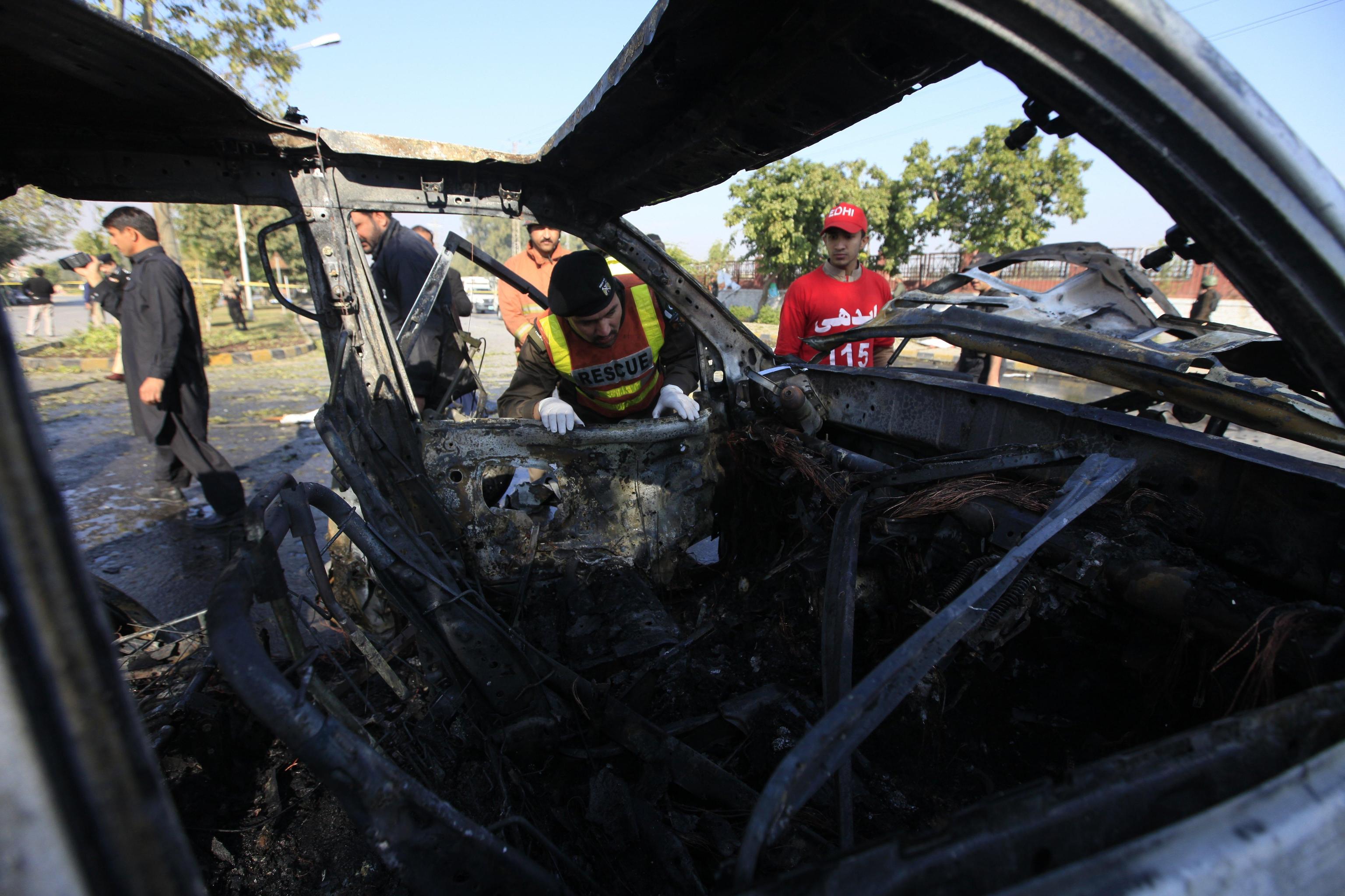Ufficiali pakistani di pubblica sicurezza ispezionano la scena dell'attentato