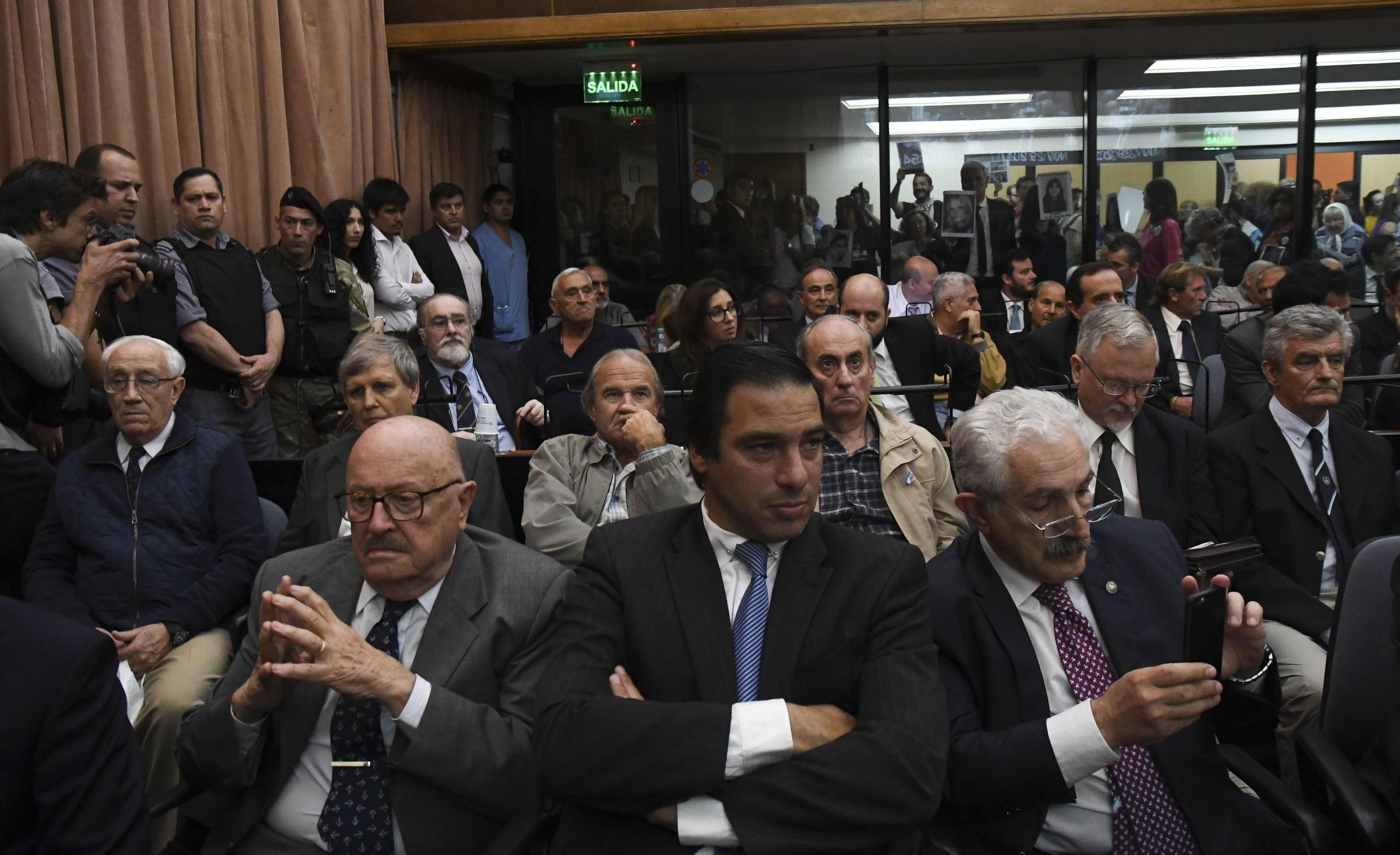 Gli ex ufficiali militari, Jorge Eduardo Acosta e Alfredo Astiz (entrambi a sinistra in seconda fila), ascoltano la lettura della sentenza presso le corti federali di Buenos Aires Gli ex ufficiali militari, Jorge Eduardo Acosta e Alfredo Astiz (entrambi a sinistra in seconda fila), ascoltano la lettura della sentenza presso le corti federali di Buenos Aires