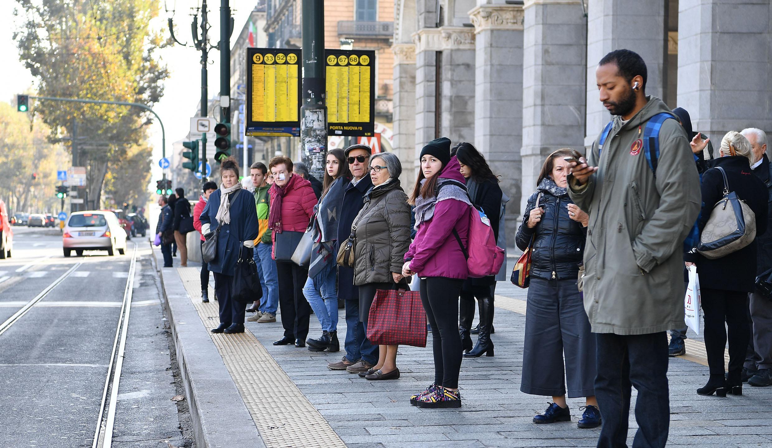La fermata dell'autobus davanti alla Stazione Porta Nuova di Torino gremita di gente