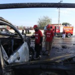 Gli ufficiali di sicurezza pakistani ispezionano i resti del veicolo sul quale viaggiavano l'agente di polizia e i suoi aiutanti