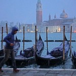 Uomo corre sotto la neve sul lungomare veneziano