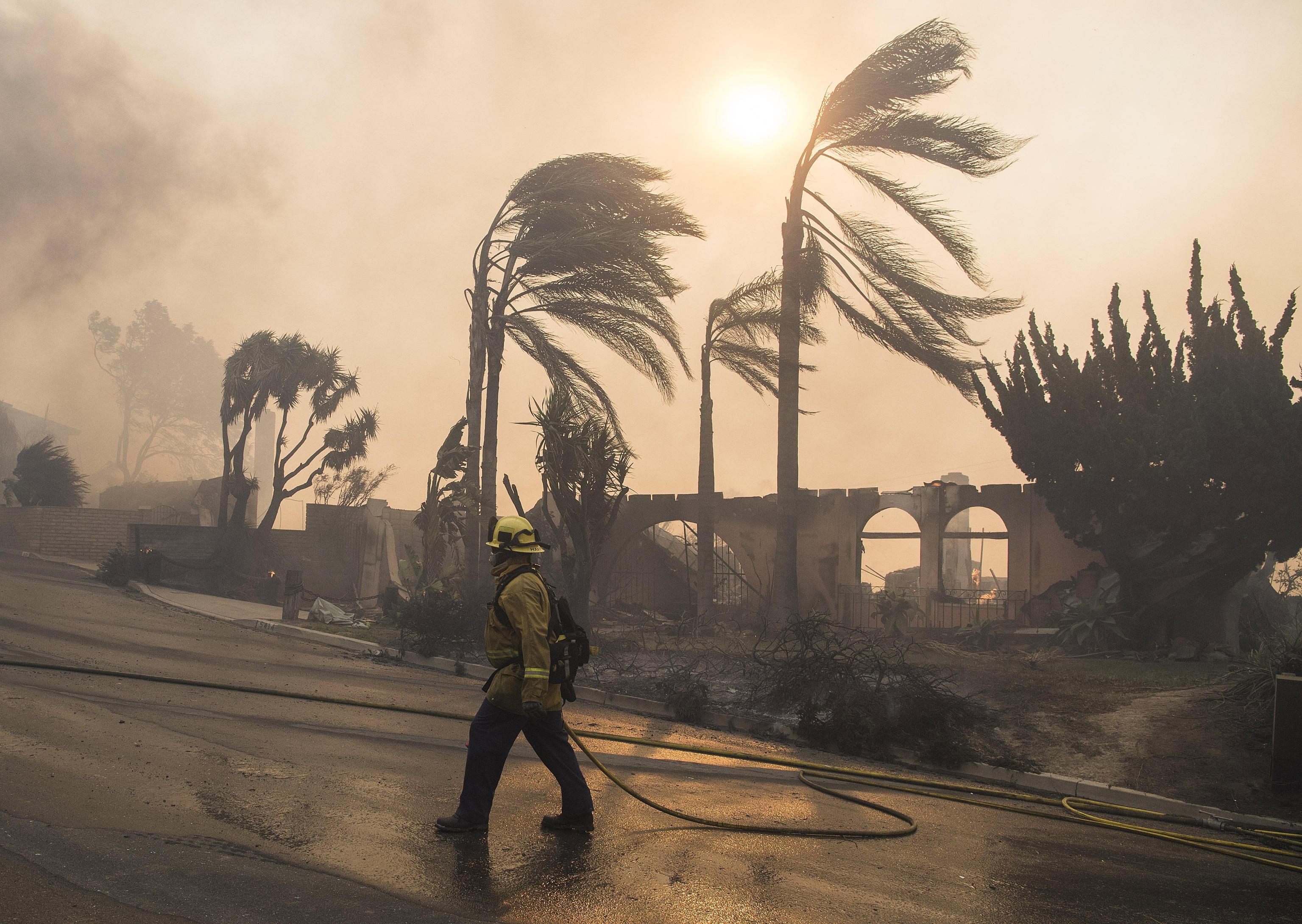 Un pompiere cammina per le strade di Ventura invase dal fumo