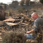 Un uomo siede fra le rovine di una casa distrutta a Ventura