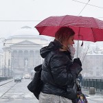 Passante cerca di proteggersi dalla neve con un ombrello