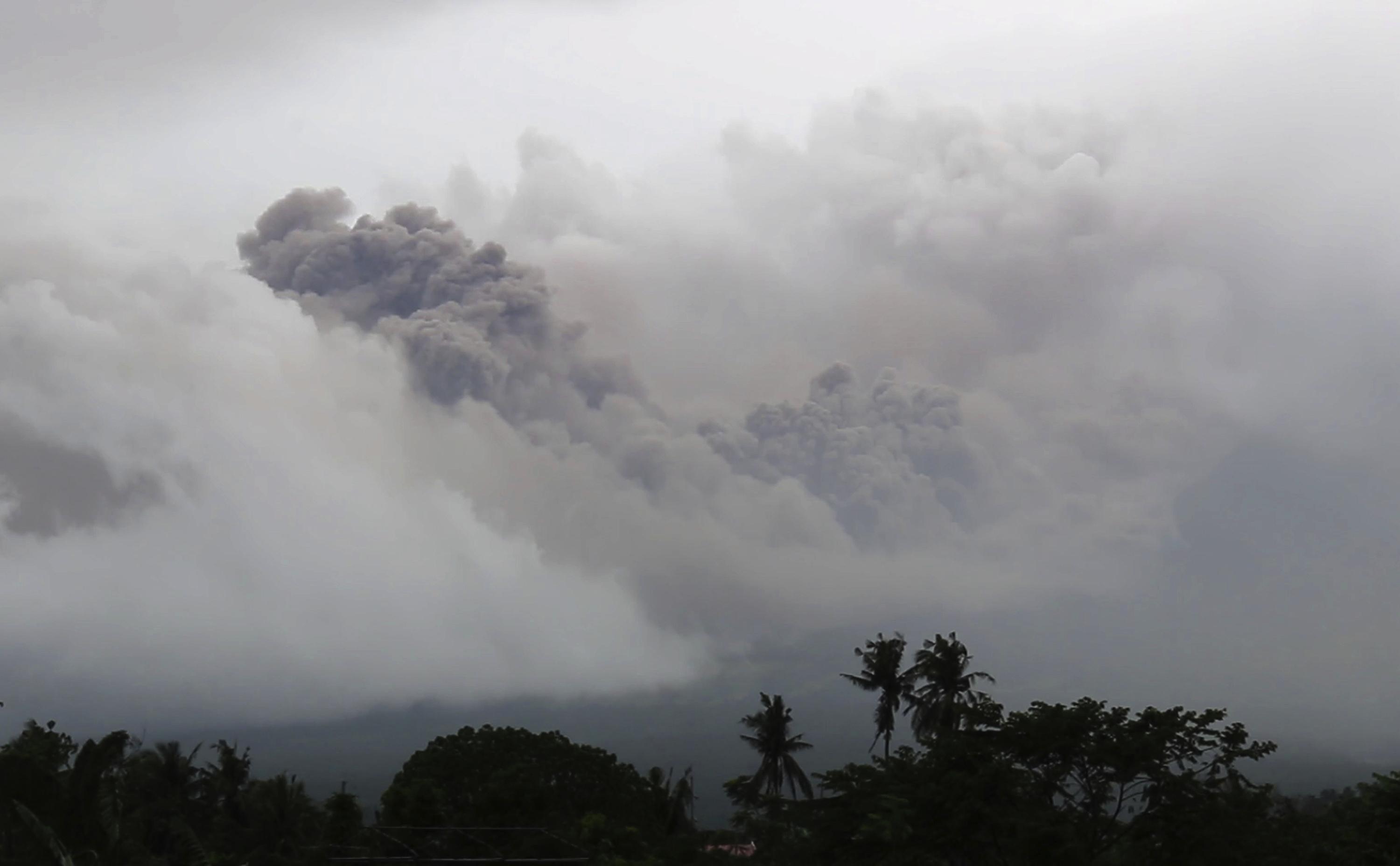 La nube di cenere piroclastica del vulcano Mayon visto dalla città di Legazpi, nella provincia di Albay