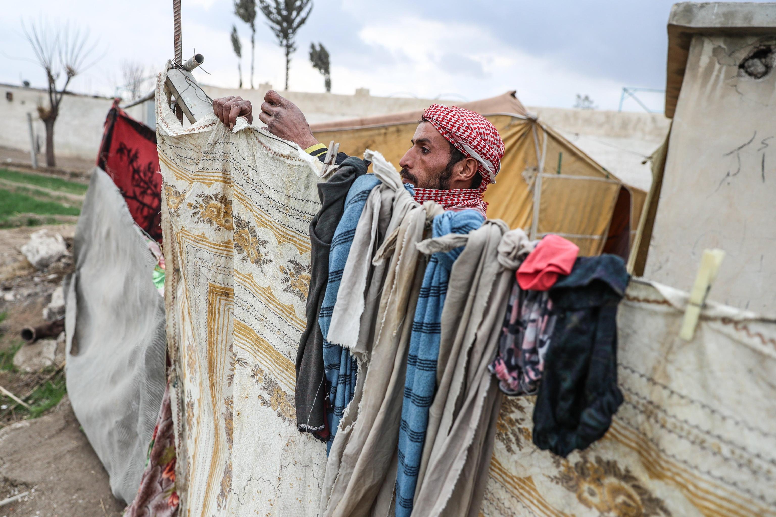 Un uomo stende i panni fuori dal suo rifugio Un uomo stende i panni fuori dal suo rifugio