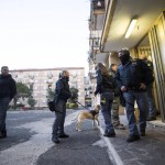 I poliziotti all'esterno di uno dei palazzi perquisiti