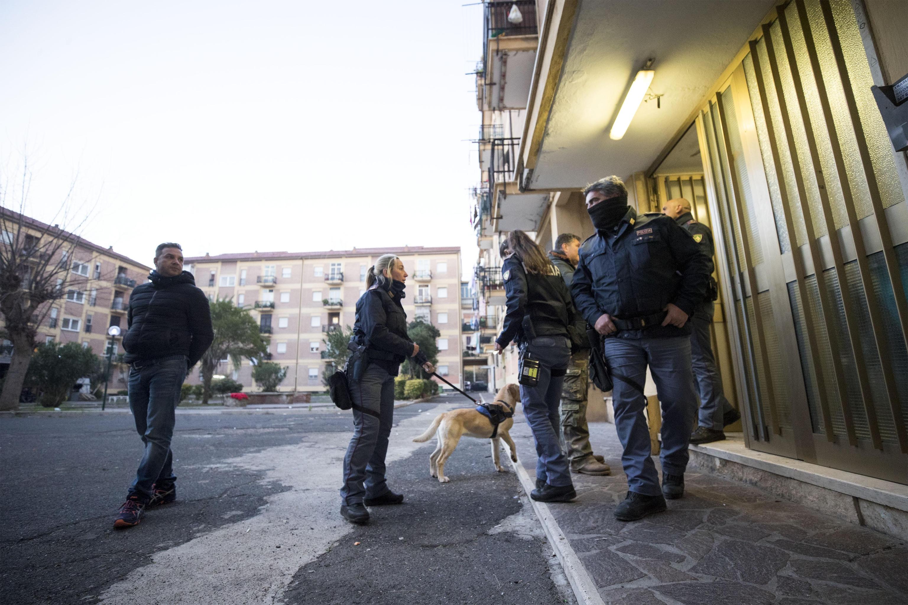 I poliziotti all'esterno di uno dei palazzi perquisiti