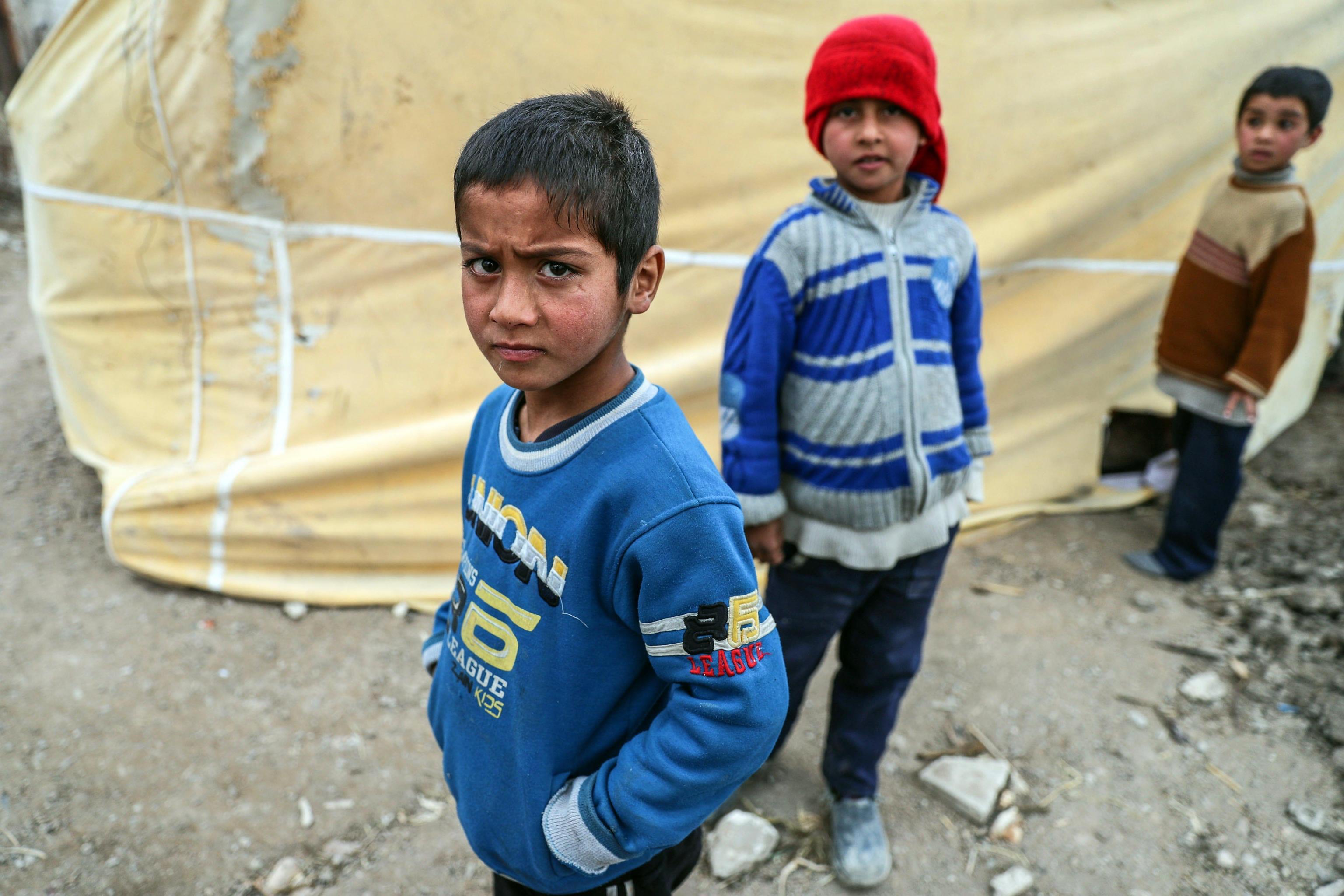 Bambini sfollati davanti a una tenda Bambini sfollati davanti a una tenda
