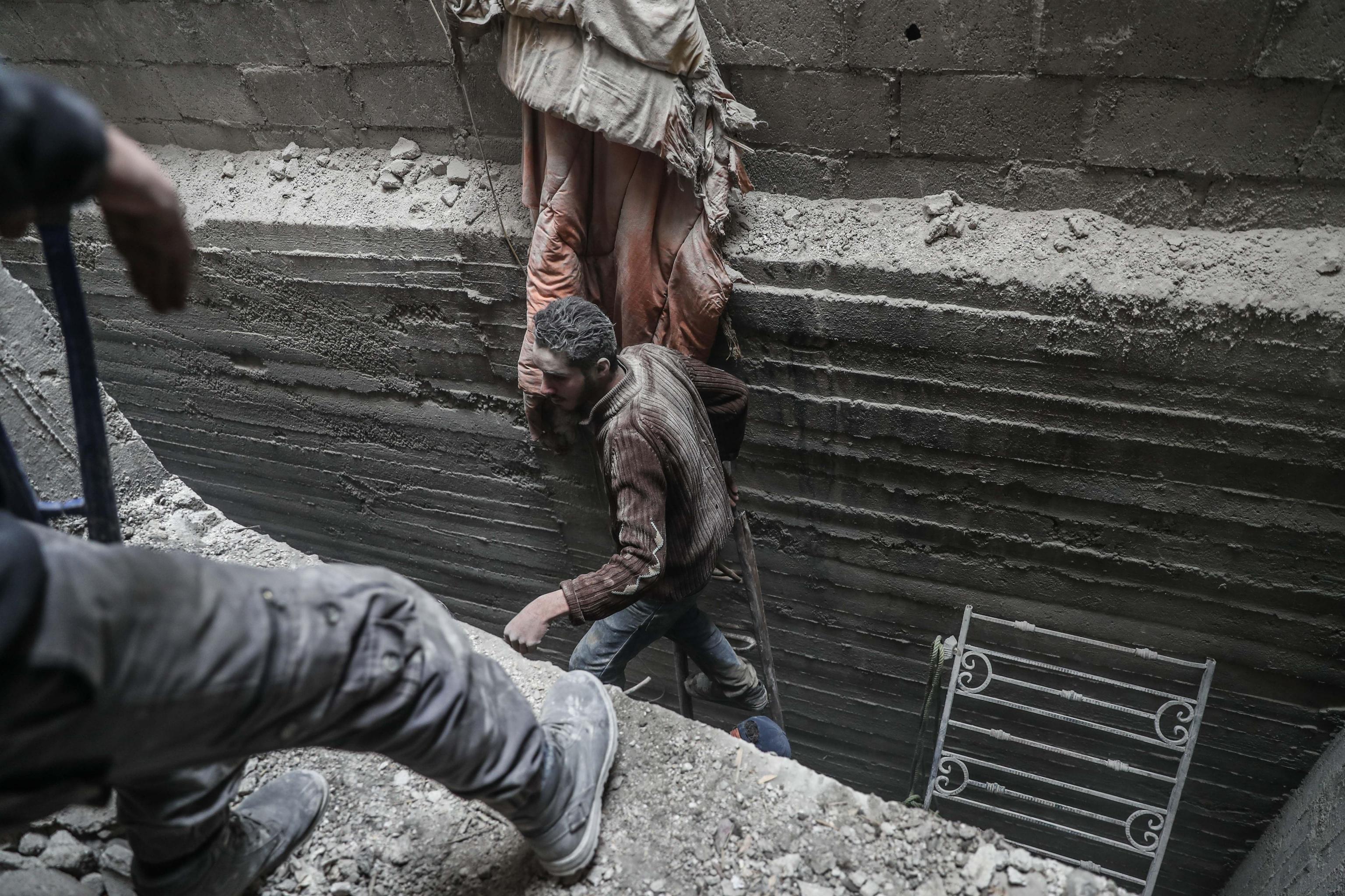 Volontari alla ricerca di superstiti tra le rovine degli edifici bombardati a Douma, est della Ghouta Volontari alla ricerca di superstiti tra le rovine degli edifici bombardati a Douma, est della Ghouta