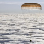 La capsula Soyuz appena sopra le nuvole. Tra poco toccherà Terra La capsula Soyuz appena sopra le nuvole. Tra poco toccherà Terra