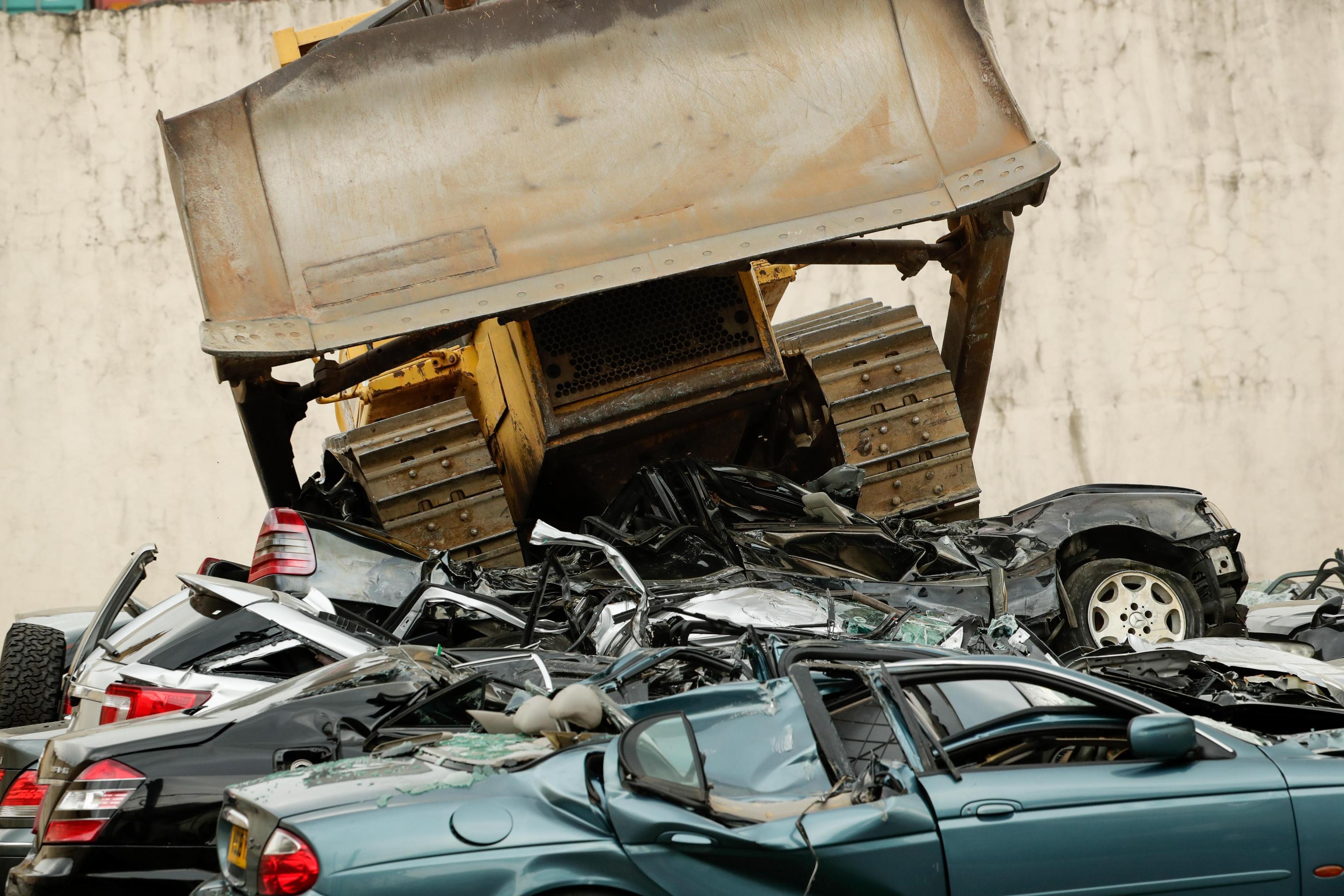 ...Che passeggiano sopra una ventina di auto di lusso