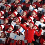 I coreani cantano tenendo la bandiera dell'unificazione coreana durante la pre-cerimonia